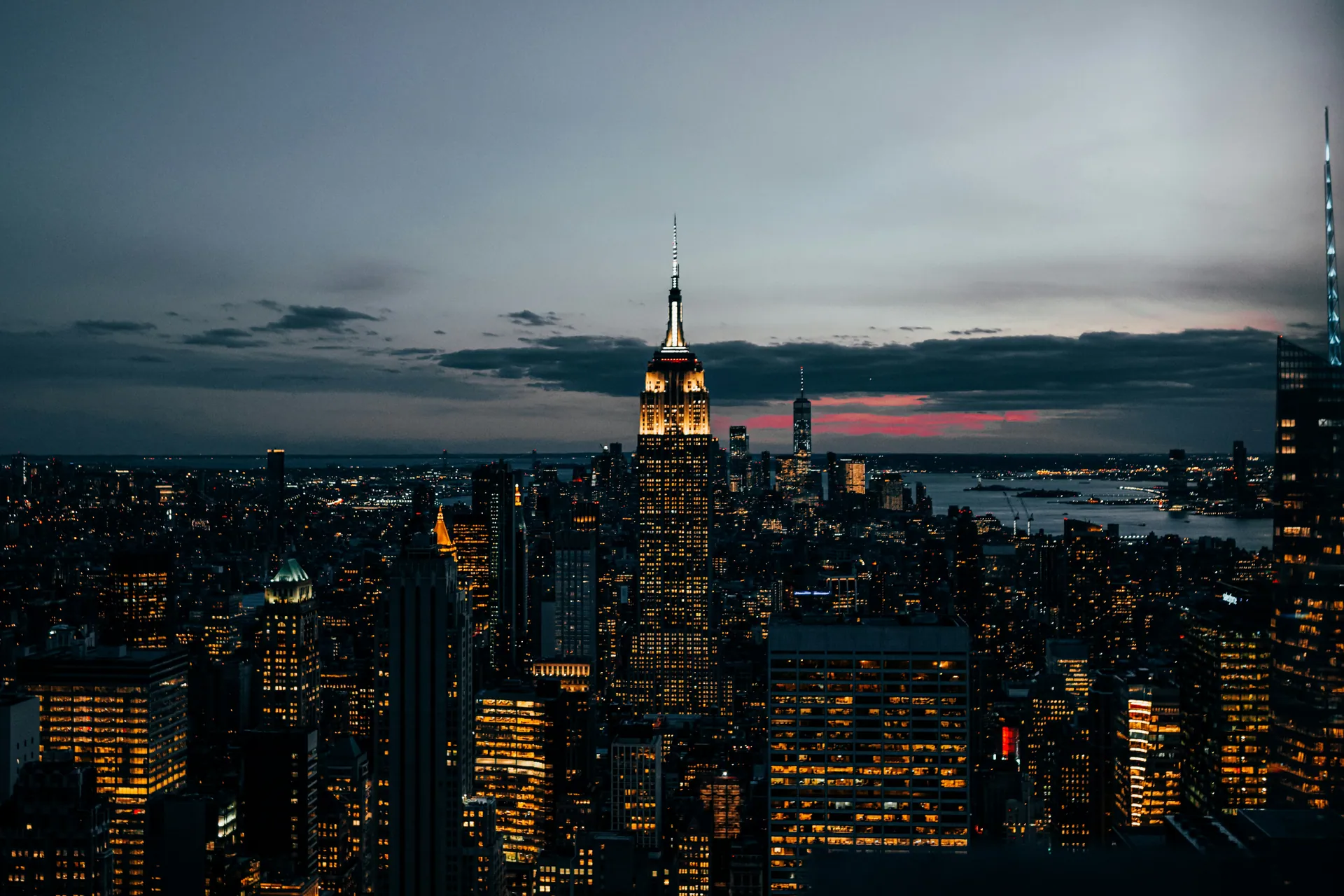 Midtown de Nova York vista do alto ao anoitecer, com o Empire State iluminado.